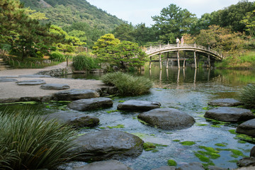 Fototapeta na wymiar Stepping stones and bridge in Ritsurin Garden in Takamatsu　栗林公園 偃月橋と吹上の飛び石