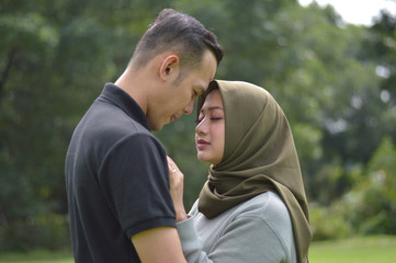 lovely asian Muslim young couple embracing at outdoors