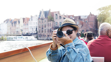 Outdoor lifestyle portrait of pretty young woman having fun in the city in Europe with digital camera travel photo of photographer Making pictures in hipster style