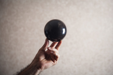 Man holding black crystal ball.