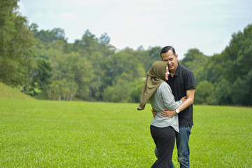 lovely asian Muslim young couple embracing at outdoors