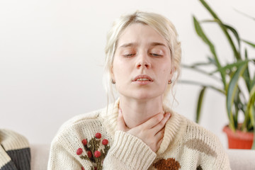 The girl in the sweater is sick. Colds and flu. The patient caught a cold, feeling sick and sore...