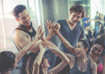 Fitness Gym friend having fun with in the gym placing hand together, team work and togetherness and sport healthy lifestyle concept.