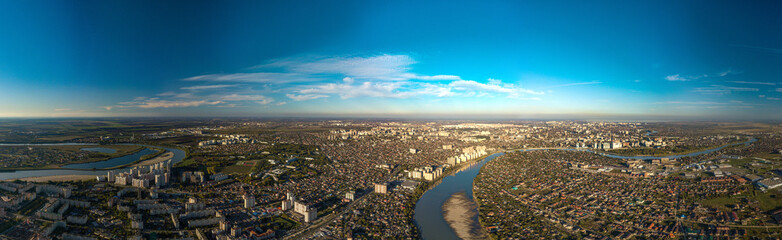 Panorama view over the western outskirts of the city of Krasnodar and the winding Kuban River at the end of an autumn day before sunset