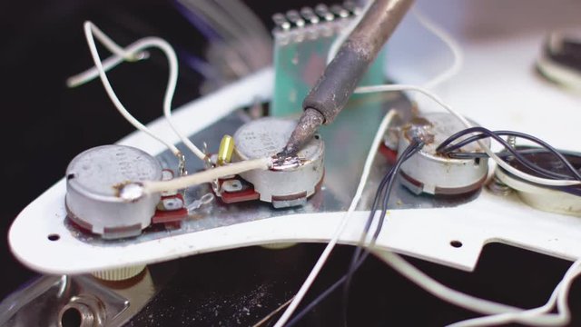 Soldering close up, luthier fixing a guitar