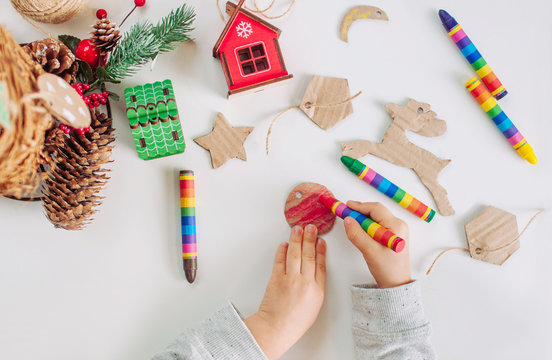 Kids hands drawing handmade corrugated cardboard decoration for Christmas tree