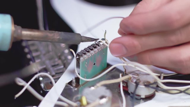Close up of soldering electrical element of a guitar