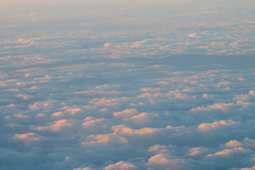Un mar de nubes con los colores cálidos del atardecer. Fotografía desde un avión.
