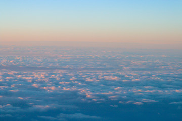 Fototapeta na wymiar Un mar de nubes con los colores cálidos del atardecer. Fotografía desde un avión.