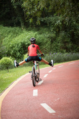 Fototapeta premium Woman cyclist riding mountain bike outdoors,have fun with legs on handlebar