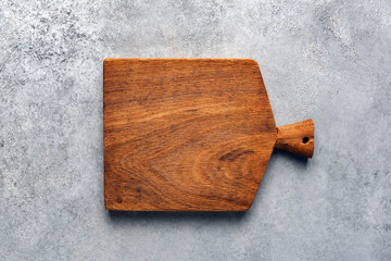 Rough square modern wooden cutting board on concrete background. Top view copy space. Kitchen, cooking food, menu background