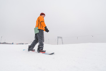 Fototapeta na wymiar man snowboarding down by hill