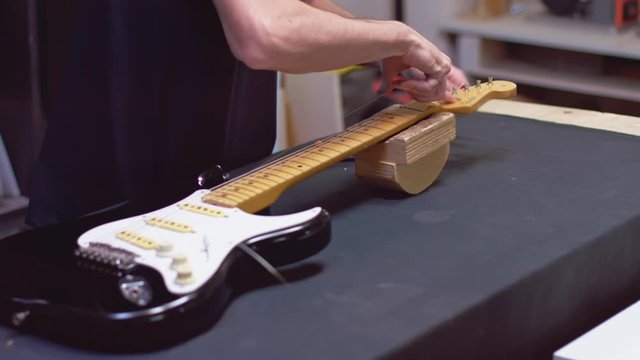 Guitar maker in his lab repaiRs guitar strings