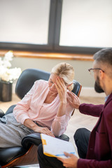 Bearded young psychologist supporting client during psychoanalysis