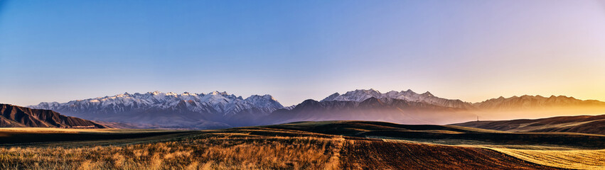 Panorama of a mountain valley in autumn evening. Fairytale sunset over the mountain peaks, amazing nature of the foothills, autumn in the mountains. Travel, tourism. beautiful background picture