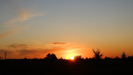 Happy new day concept: summer sunrise over beautiful field and stunning sky