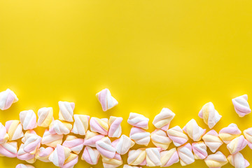 Sweets. Marshmallows frame on yellow background top view copy space