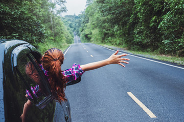 Asian women travel relax in the holiday. Traveling by car park. happily With nature, rural forest. In the summer. Woman driving a car traveling happily.