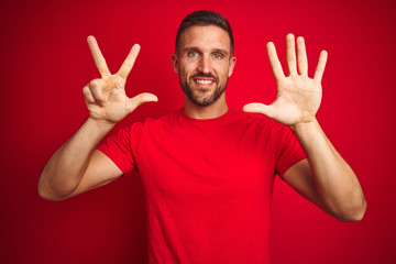 Naklejka premium Young handsome man wearing casual t-shirt over red isolated background showing and pointing up with fingers number eight while smiling confident and happy.