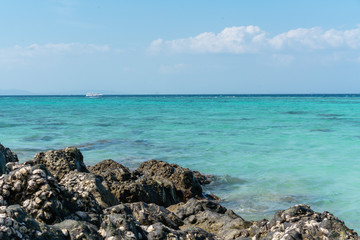 Mountain of stones against the background of the turquoise sea. Summer