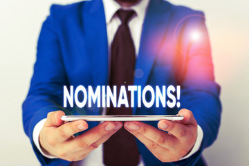 Handwriting text writing Nominations. Conceptual photo action of nominating or state being nominated for prize Businessman in blue suite with a tie holds lap top in hands