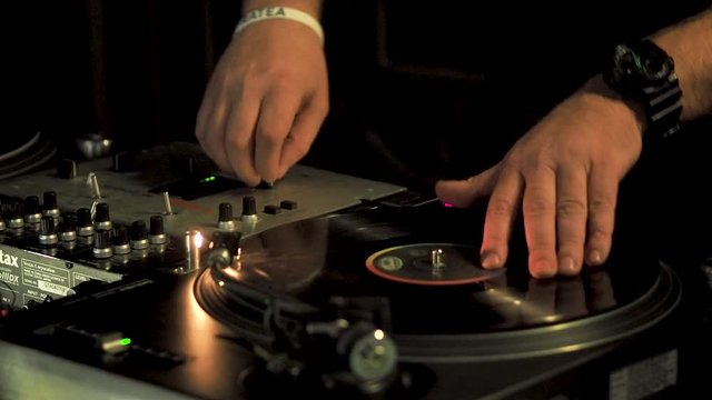 Real DJ at night garden party, scratching, mixing, beat-matching and seeking track.