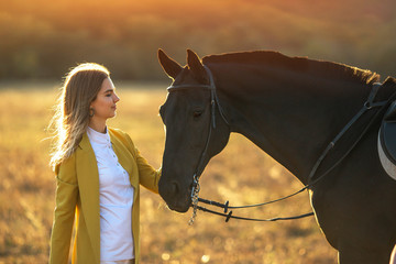 Lovely young girl hugs her horse.