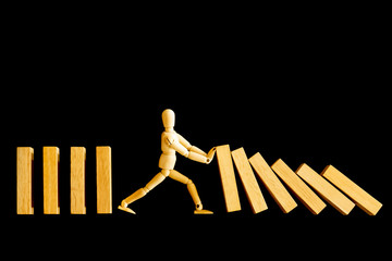 Wooden man model or businessman against and stopping the risk of falling domino effect isolated on...