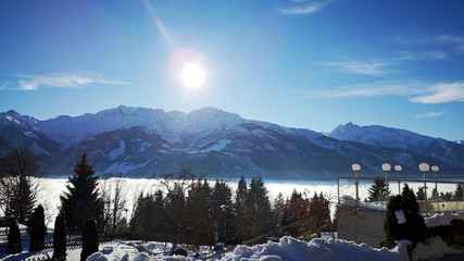 fog in the valley and sunshine on the mountains in winter with view to the alps