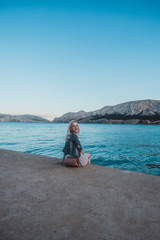 young woman on the beach by the sea with mountain view