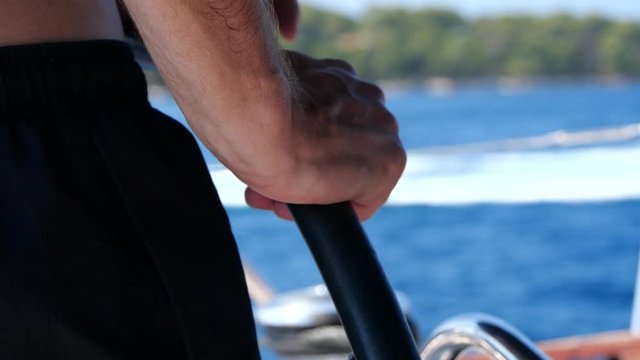 Sailing trip. Footage of the male skipper holding the helm or stere on a yacht.