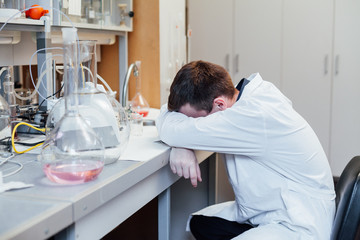scientist sleeps in the workplace in a medical laboratory