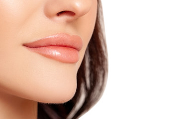 Fototapeta premium Part of face, young woman close up. Sexy plump lips. Beauty concept. Female lips. Closeup mouth Nude Colors lacquered. Sexy lips, Make up. face in profile, smile