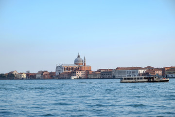 Venice, landscape view of lagoon canal with redentore church and touristic boat