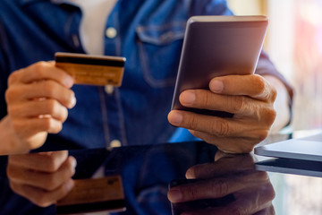Casual business man using credit card for online payment.