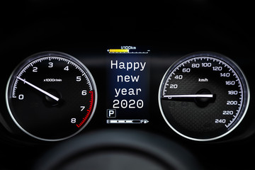 Fototapeta premium Close up Instrument automobile panel with Odometer, speedometer, tachometer, fuel level, which says Happy New Year 2020. The concept of the new year and Christmas in the automotive field.