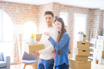 Young asian couple holding keys of new house, smiling happy and excited moving to a new apartment