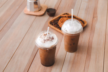 Cups of tasty frappe coffee on wooden table