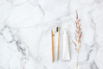 Set of eco-friendly toothbrushes and toothpaste on marble background. Dental and healthcare concept. Top view, flat lay. Free copy space.