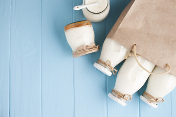 Jars and bottles of milk in paper bag