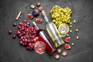 Different tasty wine with grapes on dark background