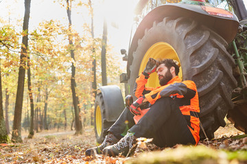 Waldarbeiter macht Pause am Traktor im Wald © Robert Kneschke