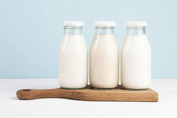 Bottles filled with milk on chopping board