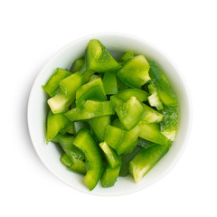 Chopped green pepper in bowl isolated on white background. Top view
