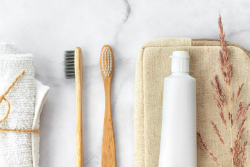 Set of eco-friendly toothbrushes, toothpaste and cotton towel on marble background. Dental and...