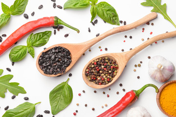 Spoons with different spices on white background