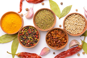 Bowls with different spices on white background