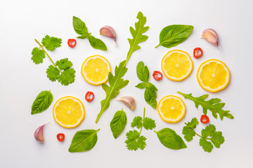 Lemon slices with different herbs on white background