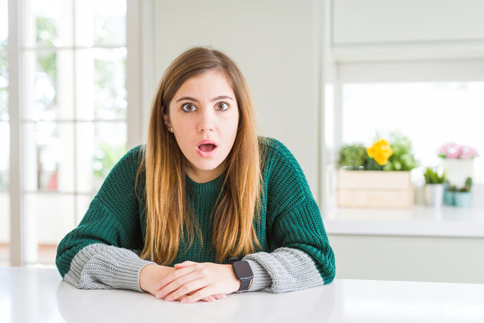 Young beautiful plus size woman wearing casual striped sweater afraid and shocked with surprise and amazed expression, fear and excited face.