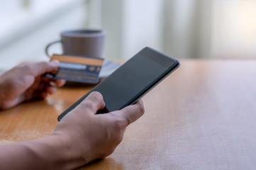 Man hand holding and using mobile smart phone and credit card for online shopping and payment.